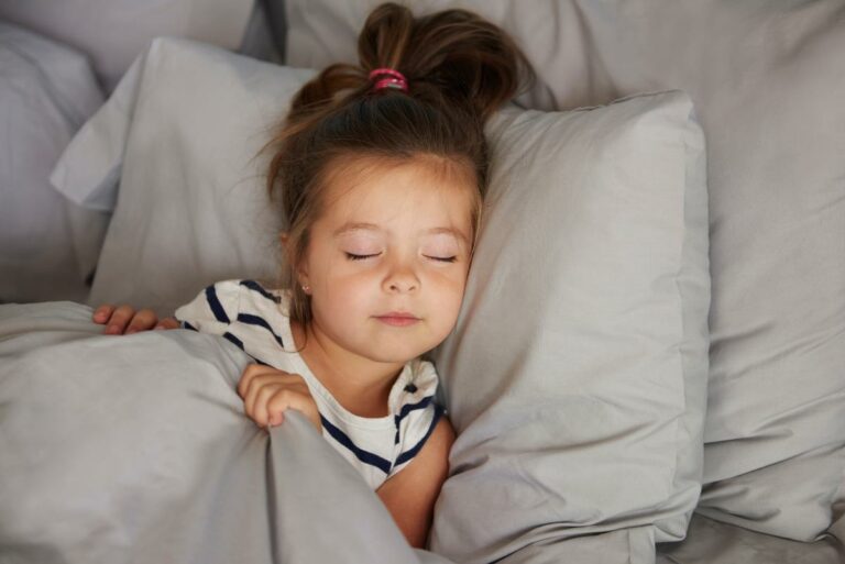 menina dormindo na cama contra o travesseiro