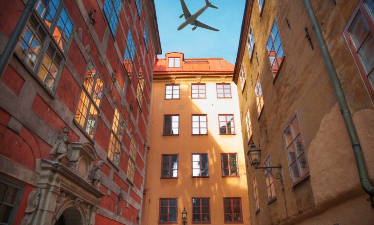 avião sobrevoando um prédio residencial. É vantagem ou desvantagem morar próximo ao aeroporto?