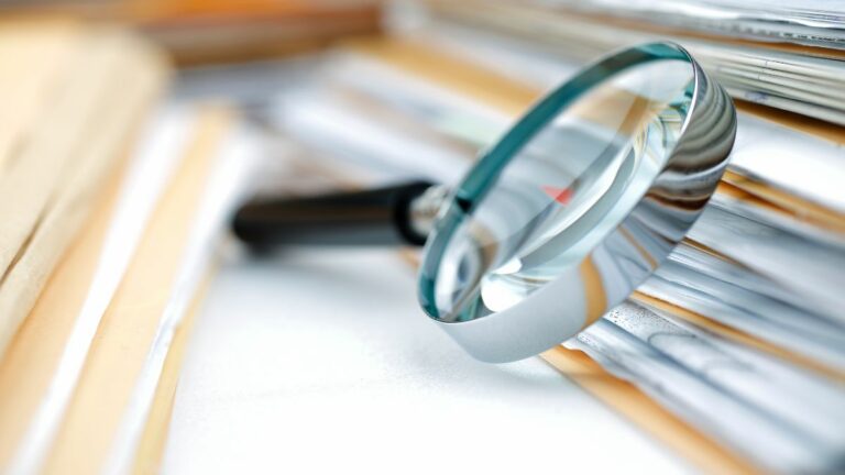 lupa ao lado de documentos.
