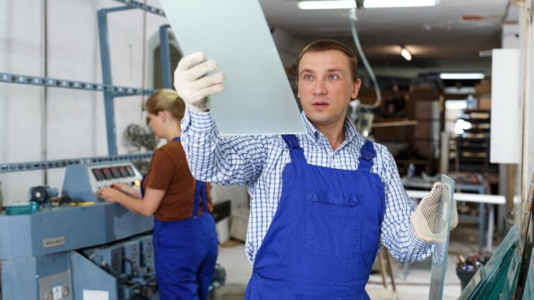 vidraceiro inspecionando peça de vidro.